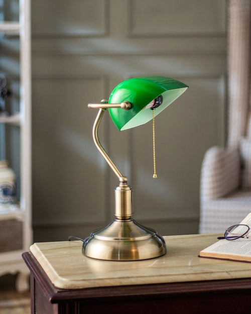 Banker table lamp emerald green shade illuminated on desk