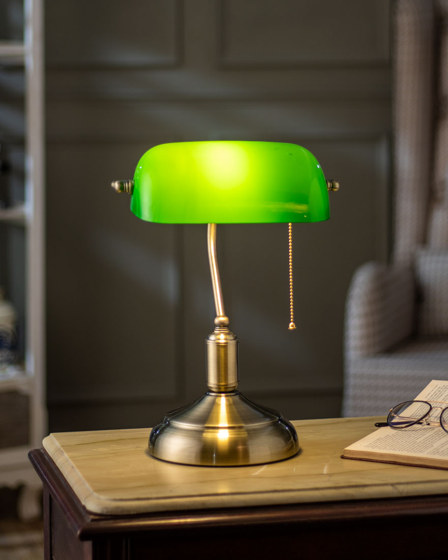 Close-up of emerald green glass shade on brass banker lamp