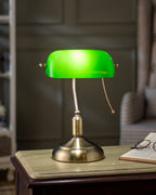 Polished brass base detail of emerald green banker table lamp