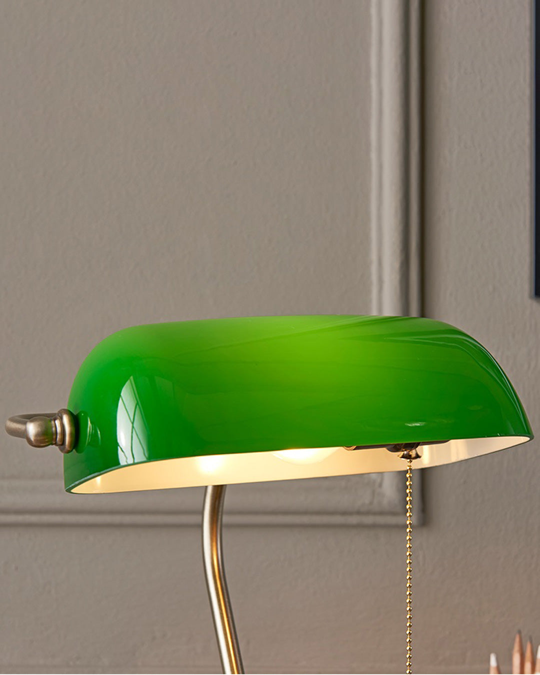 Banker table lamp with emerald green shade in home office setting