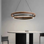 Minimalist circular chandelier hanging above modern dining room table