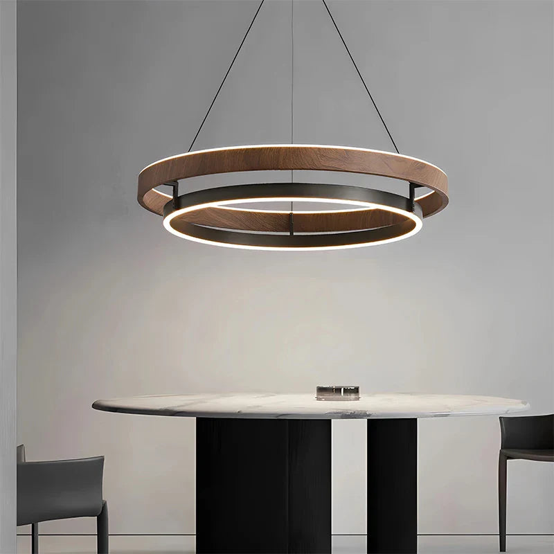 Minimalist circular chandelier hanging above modern dining room table